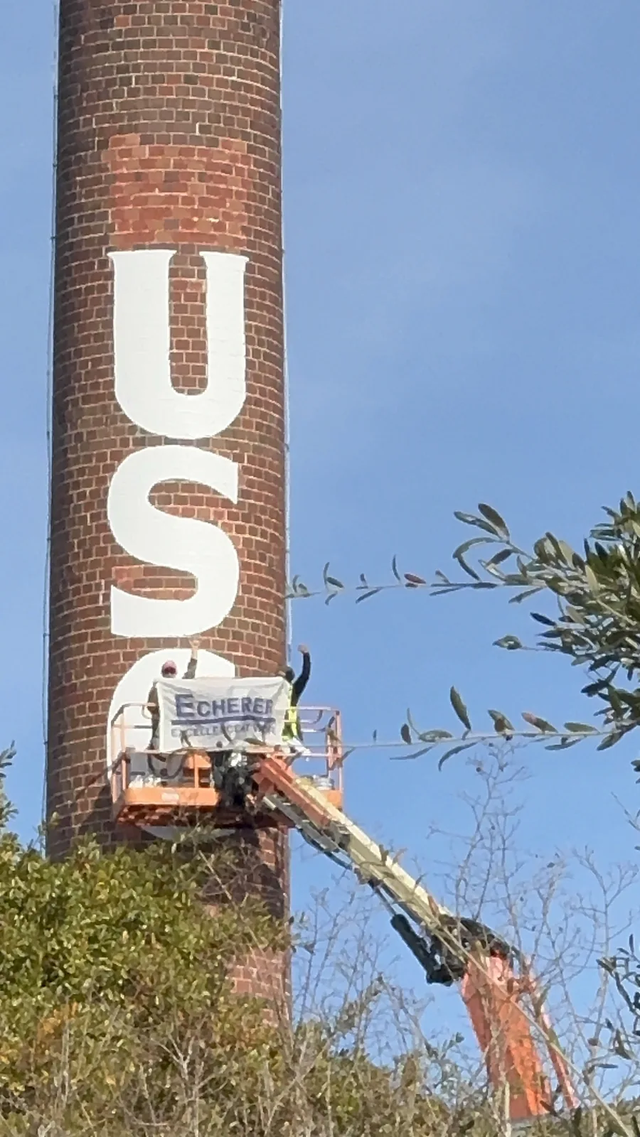 ECHERER crew flying the company banner while painting the USC smokestack